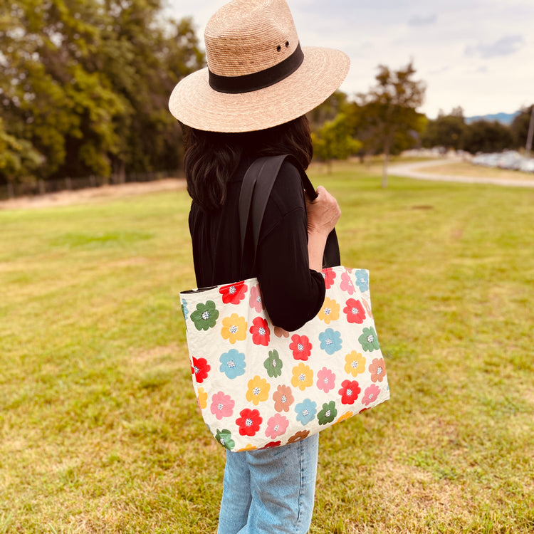 woman holding a cream bag with colorful flowers